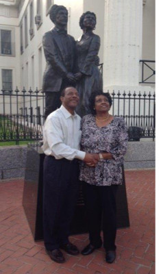 Curtis and Jannice May pose by a statue of Dred and Harriet Scott