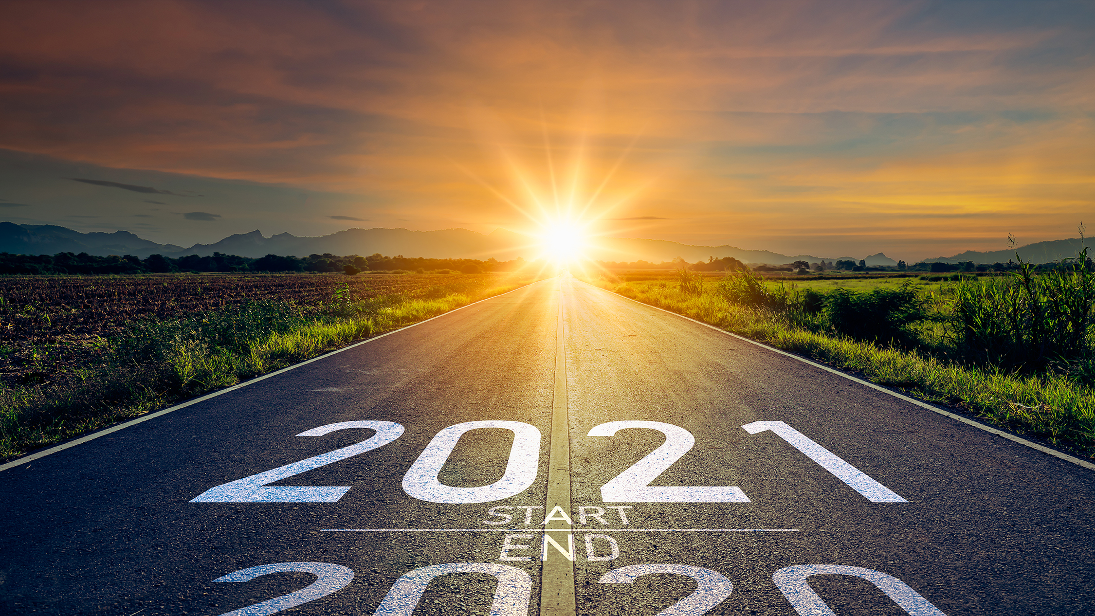 New year 2021 or start straight concept.word 2021 written on the New year 2021 or start straight concept.word 2021 written on the road in the middle of asphalt road at sunset.Concept of planning and challenge or career path,business strategy,opportunity and change