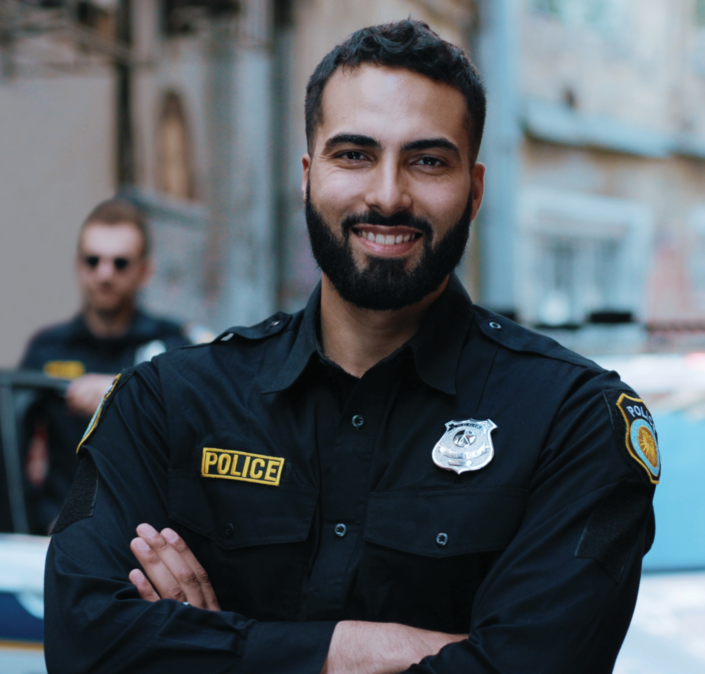 Smiling young man cops stand near patrol car look at camera enforcement happy officer police uniform auto safety security communication control policeman portrait close up slow motion